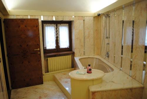 La salle de bains est pourvue d'une baignoire, d'un lavabo et d'une douche. dans l'établissement Hotel Locanda San Giacomo, à Agliano Terme