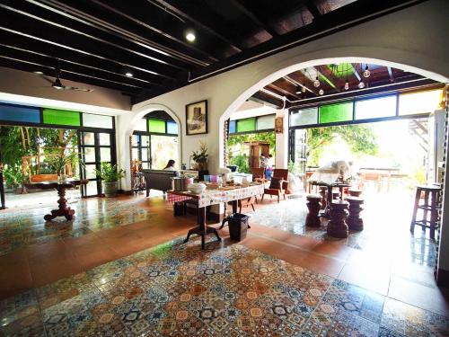 Pround Nan Cottage في نان: غرفة معيشة مع طاولات وكراسي ونوافذ