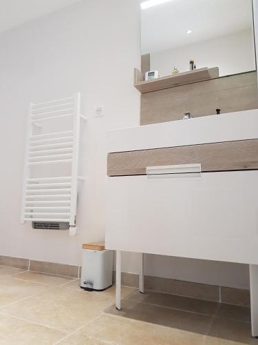 une salle de bain avec un lavabo blanc et un miroir dans l'établissement Séjour Pic Saint Loup, à Saint-Mathieu-de-Tréviers
