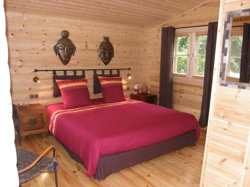 a bedroom with a bed in a log cabin at Tumbleweed House in Aigrefeuille