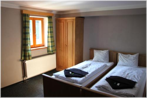 a bedroom with two beds with black pillows on them at Hotel Alba in Deštné v Orlických horách