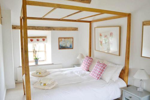 ein Schlafzimmer mit einem großen weißen Bett mit zwei Handtüchern darauf in der Unterkunft Hampton Wafre Cottage in Docklow
