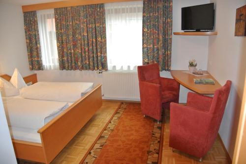 a hotel room with a bed and a table and chairs at Gasthof Zum Stollhofer in Inzing