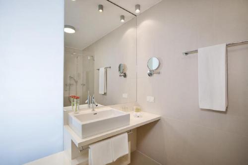 a white bathroom with a sink and a mirror at Schönberghof Spielberg in Spielberg