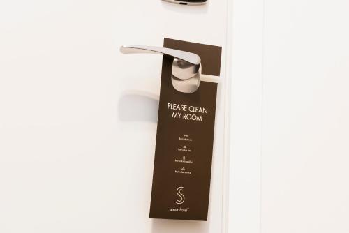 a black tag hanging on a white wall at Smarthotel Tromsø in Tromsø