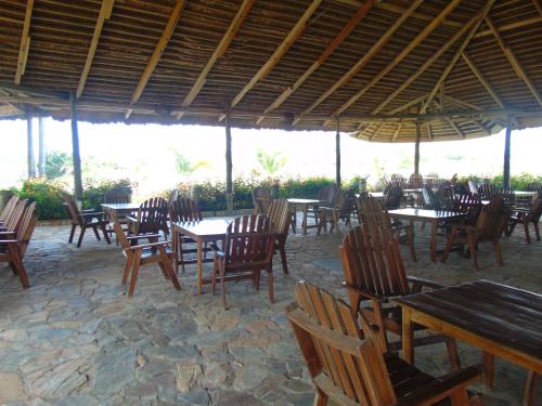 a group of tables and chairs in a restaurant at Bojo Beach Resort in Bortianor