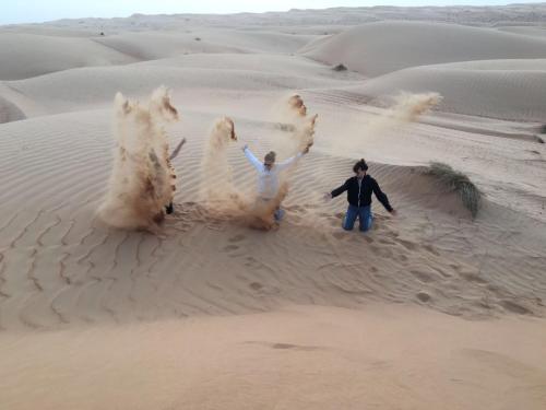 a group of people playing in the sand at Oriental Nights Rest House in Al Wāşil