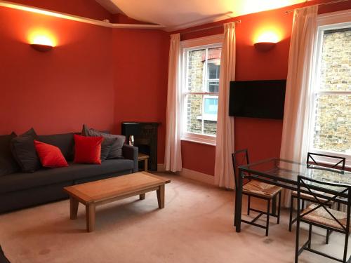 a living room with a couch and a table at Wix's Lane in London