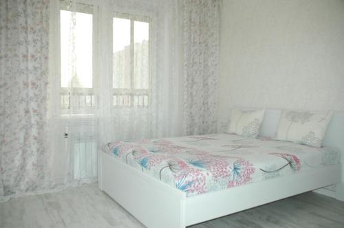 Апартаменты ул Спортивная 17 Люкс с Джакузи في كيميروفو: غرفة نوم بيضاء بها سرير ونافذة