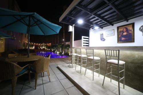 a restaurant with chairs and tables and an umbrella at Aquamarina Hotel in Manta