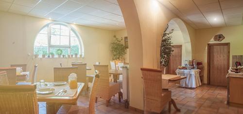 a dining room with tables and chairs and a window at B&B Na Kluk in Idrija