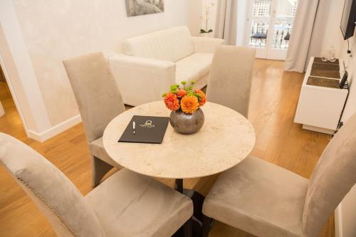 a dining room table with a bowl of flowers on it at Amazing Piazza Venezia Suites in Rome