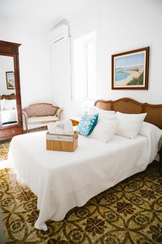a large white bed with a wooden box on it at Mateo Alemán 22 in Seville