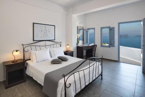 a bedroom with a bed and a desk with a desk at Apanemo Hotel & Suites in Akrotiri