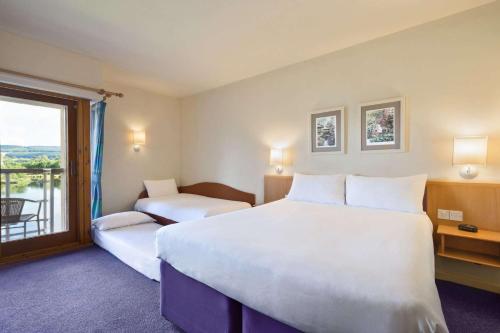 a hotel room with a large bed and a window at Days Inn Lockerbie - Annandale Water in Johnstonebridge