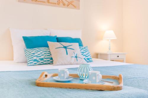 a tray with cups and saucers on a bed at Beautiful Apartment Litoralmar in Portimão