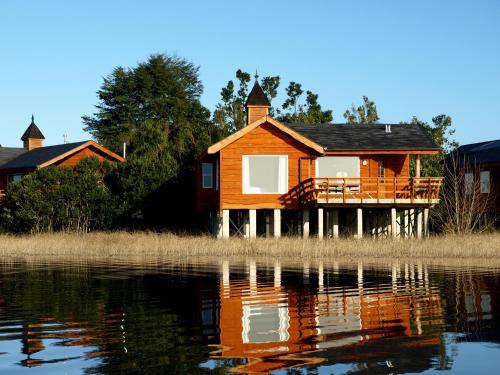 a house on the shore of a body of water at CABAÑAS Gracias a la Vida Lodge in Puerto Varas