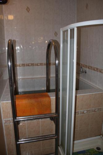 y baño con ducha y asiento de color naranja. en Комплекс отдыха "Престиж", en Boryspilʼ
