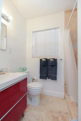 a bathroom with a toilet and a sink and a window at The Dolphin Hollywood in Hollywood