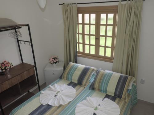 1 dormitorio con 1 cama con 2 sombrillas en Pousada Solar do Jabaquara, en Paraty