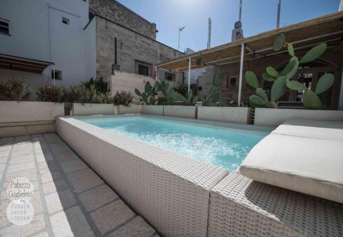 a swimming pool with a mattress in front of a building at Palazzo Guglielmo in Vignacastrisi