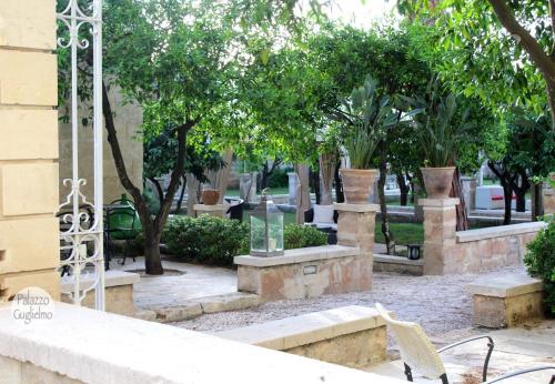 a park with benches and trees and a building at Palazzo Guglielmo in Vignacastrisi