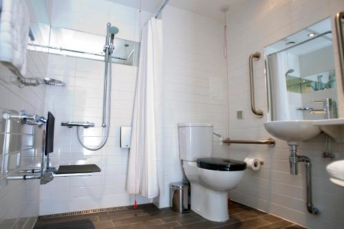a bathroom with a toilet, sink, and shower stall at Sleeperz Hotel Newcastle in Newcastle upon Tyne