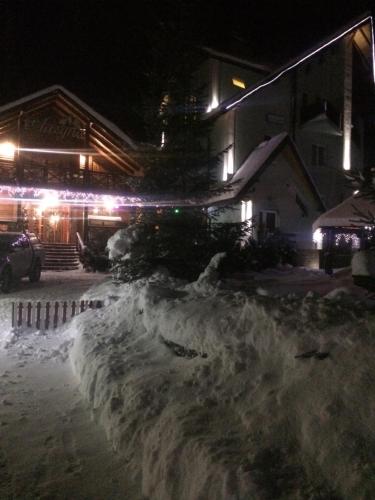 a pile of snow in front of a building at night at Laguna in Slavske