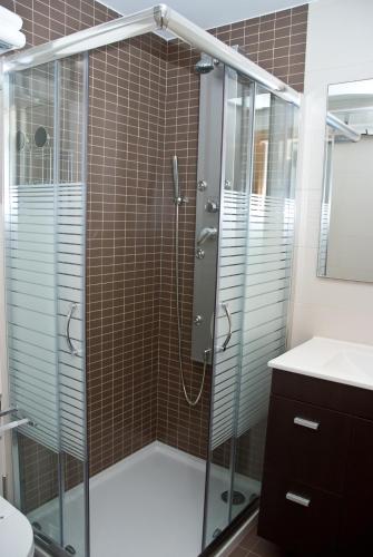 a shower with a glass door in a bathroom at Apartamentos Domus Stellae in Santiago de Compostela