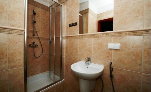 y baño con lavabo y ducha. en Amelia Apartamenty - sala zabaw, garaż podziemny, en Władysławowo