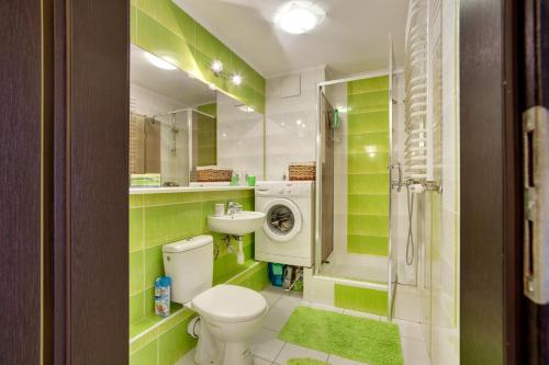 a green bathroom with a toilet and a sink at Apartament 5 in Krakow