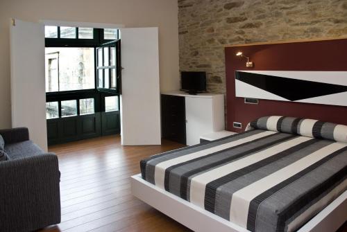 a bedroom with a bed with a black and white striped blanket at Apartamentos Domus Stellae in Santiago de Compostela