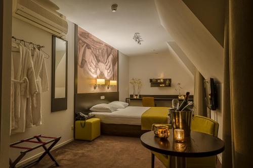 a hotel room with a bed and a table at Parkhotel Auberge Vincent in Nuenen