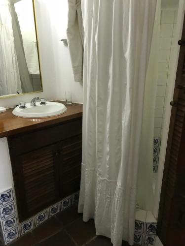 a bathroom with a shower curtain and a sink at Club Hotel Casapueblo in Punta del Este