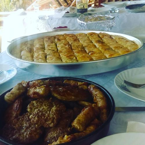 a table with a pan of food and a plate of food at Lile Pestani Accommodation in Peštani