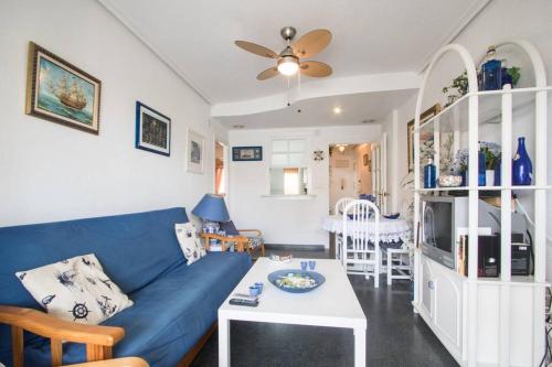 a living room with a blue couch and a table at Apartamento Costa Azahar in Santa Pola