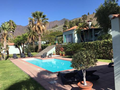 uma casa com piscina e palmeiras em La Camuesa-Adults Only em Los Llanos de Aridane