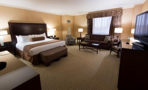 a hotel room with a bed and a chair and a television at Bally's Shreveport Casino & Hotel in Shreveport