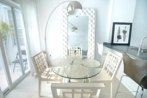 Sage on Ocean Drive Apartments في ميامي بيتش: غرفة طعام مع طاولة وكراسي زجاجية