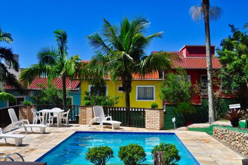 eine Villa mit einem Pool vor einem Haus in der Unterkunft Pousada Albacora in Bombinhas