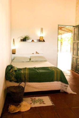 ein Schlafzimmer mit einem Bett mit einer grünen Decke darauf in der Unterkunft Pousada e Restaurante Tremembé in Icapuí