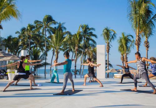 a group of people doing yoga on the beach at Marival Distinct All-Suites & World Spa - Handwritten Collection in Nuevo Vallarta 