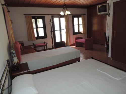 um quarto com 2 camas e uma sala de estar em Mandraki Paradise em Meyisti