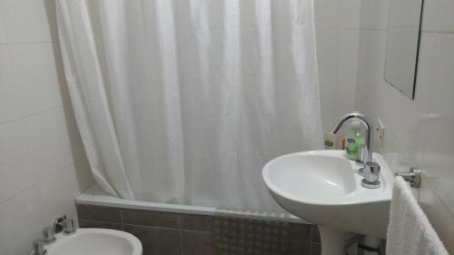 a bathroom with a sink and a shower curtain at Complejo Los Merinos in Bahía Blanca