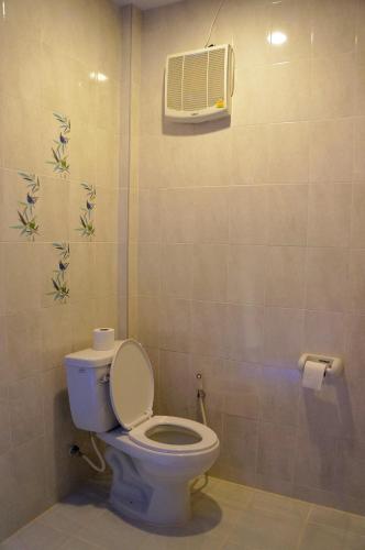 a bathroom with a toilet with a air conditioner on the wall at Chanpraya Resort in Chanthaburi