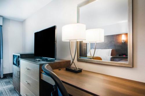a room with a desk with a television and a mirror at Comfort Inn & Suites East Ellijay in Ellijay