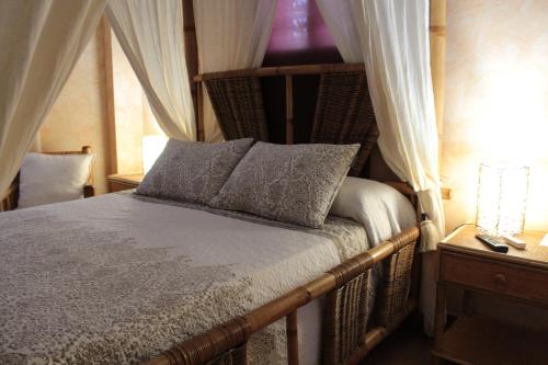a bedroom with a canopy bed and a window at Casa Rural Puerto Del Emperador in Aldeanueva de la Vera