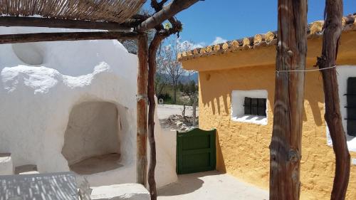 a building with a green door in a yard at Al Jatib in Baza
