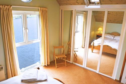 a room with a bedroom with a view of the ocean at Shelduck Lodge in South Cerney