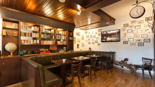 een restaurant met twee tafels en een klok aan de muur bij Hotel Villa Subklew in Ostseebad Sellin